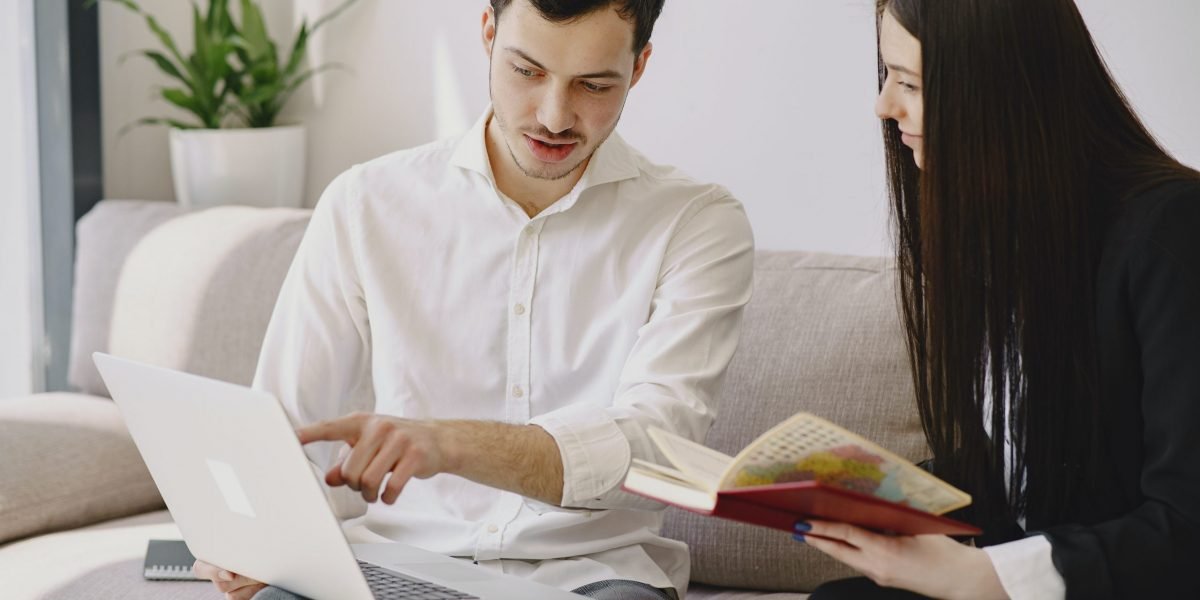 male-employee-with-laptop-interacting-with-female-colleague-4148899